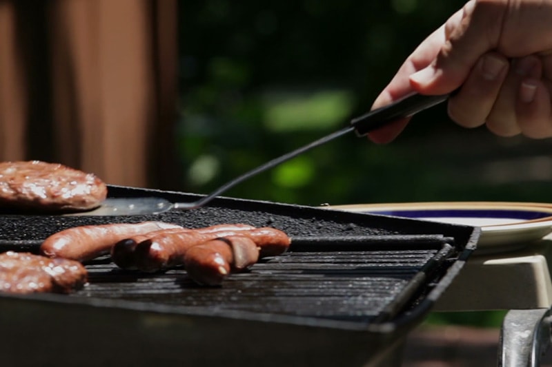 Grilling hotdogs on a grill in order to save energy in their Sherwood home